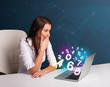 Beautiful young woman sitting at desk and typing on laptop with