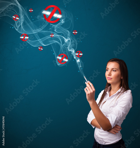 Photo: Young woman smoking dangerous cigarette with no smoking signs Young woman smoking dangerous cigarette with no smoking signs