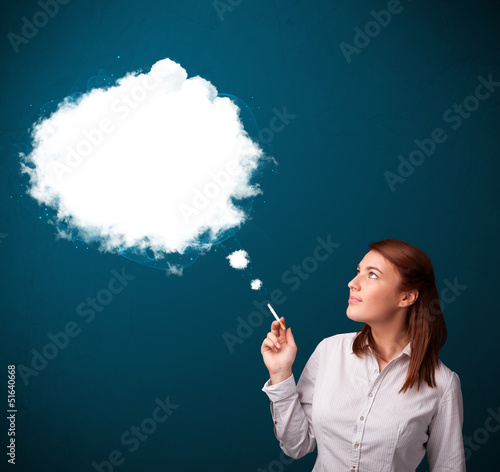 Photo: Young woman smoking unhealthy cigarette with dense smoke Young woman smoking unhealthy cigarette with dense smoke