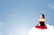 Young woman sitting on cloud with copy space