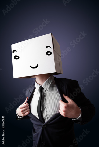 Photo: Businessman gesturing with a cardboard box on his head with smil Businessman gesturing with a cardboard box on his head with smil