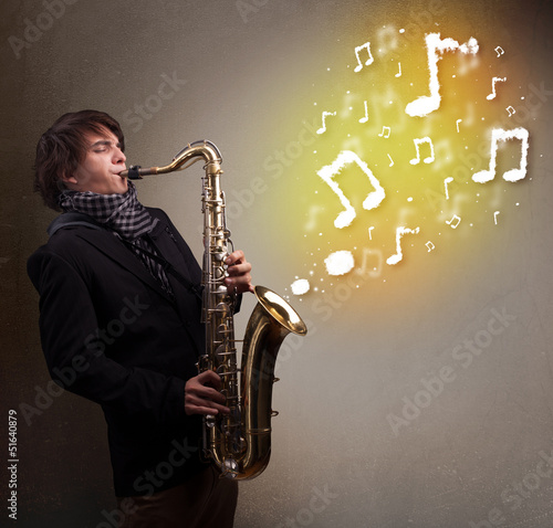 Photo: Handsome musician playing on saxophone with musical notes Handsome musician playing on saxophone with musical notes