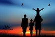 Family with children walk on a sunset