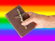 Old hand (woman) holding a very old bible, rainbow flag