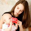 happy-looking baby wearing knitting hat and mother playing toget