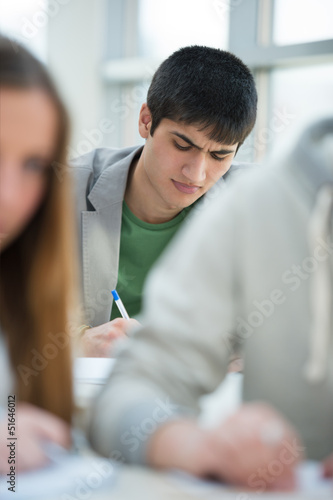 Photo: Serious students sitting for an examination in a classroom. Serious students sitting for an examination in a classroom.
