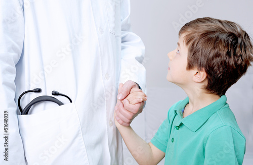 Photo: Kind blickt zu Arzt auf Kind blickt zu Arzt auf