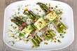 Delicious bunch of asparagus rolled with ham, zucchini, pine nut
