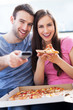 Couple with pizza and TV remote