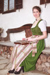 Bayerisches Mädchen beim Zither spielen auf einer Hausbank