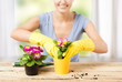 housewife with flower in pot and gardening set