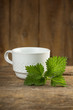 Stinging nettle ( Urtica dioica ) on wooden table
