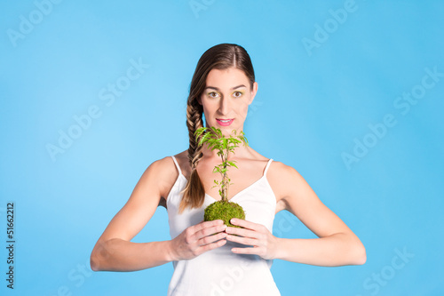 Photo: Young Woman holding a small tree Young Woman holding a small tree