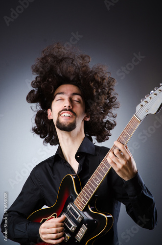 Photo: Man playing guitar during concert Man playing guitar during concert