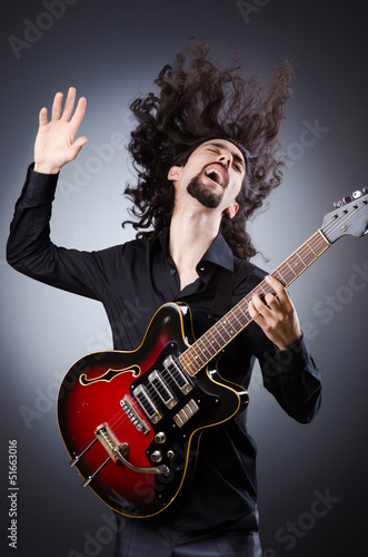 Photo: Man playing guitar during concert Man playing guitar during concert