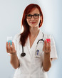 Portrait of a smiling female doctor holding two flasks