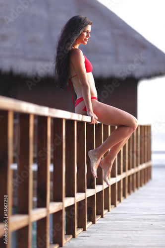 Photo: Woman in bikini near tropical hotel Woman in bikini near tropical hotel