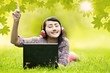 Young girl singing with laptop in park
