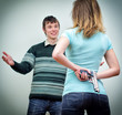 Woman hiding gun underhand talking to man