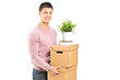 Photo: A young man carrying removal boxes A young man carrying removal boxes