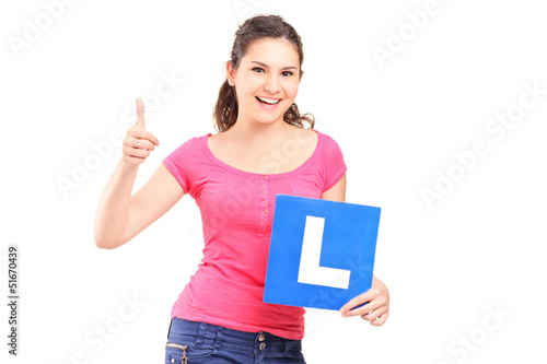 Photo: A happy teenager holding L plate and giving a thumb up A happy teenager holding L plate and giving a thumb up