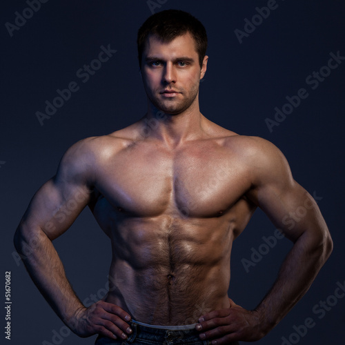 Photo: Closeup portrait of muscular guy in dark Closeup portrait of muscular guy in dark