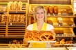 Shopkeeper in bakery with tablet of pretzels
