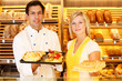 Baker and shopkeeper present pastry