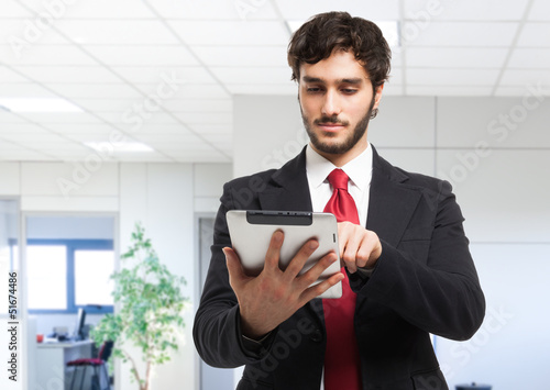 Photo: Business man holding his tablet Business man holding his tablet