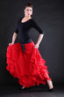 Attractive spanish young woman dancing flamenco over black backg