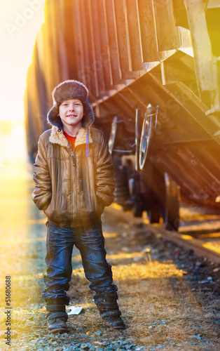 Photo: sunlight Boy homeless bum in a brown jacket and a fur hat and cr sunlight Boy homeless bum in a brown jacket and a fur hat and cr