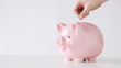 male hand inserting euro money into piggy bank
