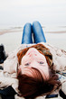 Foto: Smiling happy woman lying on the beach on a spring or autumn day Smiling happy woman lying on the beach on a spring or autumn day
