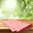 Empty wooden deck table with tablecloth over bokeh background