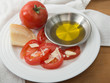 Plate of vine ripened red tomato with parmesan and olive oil
