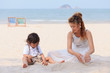 Asian mom and son playing on beach
