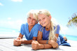 Photo: Blond teenagers laying on pool deck in summer Blond teenagers laying on pool deck in summer