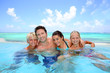 Family of four bathing in swimming pool