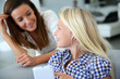 Teenager using smartphone with adult beside her