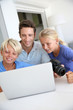 Man with teenagers looking at pictures on computer