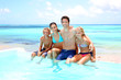Photo: Family sitting on the side of an infinity pool Family sitting on the side of an infinity pool