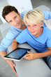 Father and son using digital tablet at home