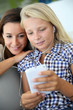 Teenager and woman listening to music with smartphone