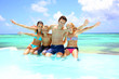 Family sitting on the side of an infinity pool
