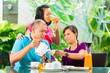 Asian friends having coffee on home porch