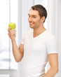 man in white shirt with green apple