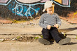 Sulking little boy sitting on a sidewalk