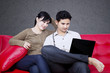 Happy couple looking at laptop on sofa