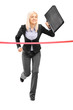 Businesswoman running with a briefcase and reaching the finish l