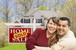 Couple in Front of Sold Real Estate Sign and House